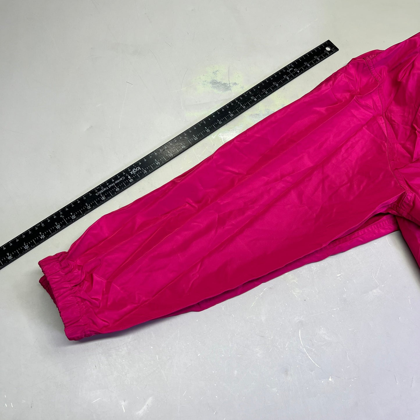 Pink pants with a ruler for size reference on a white background