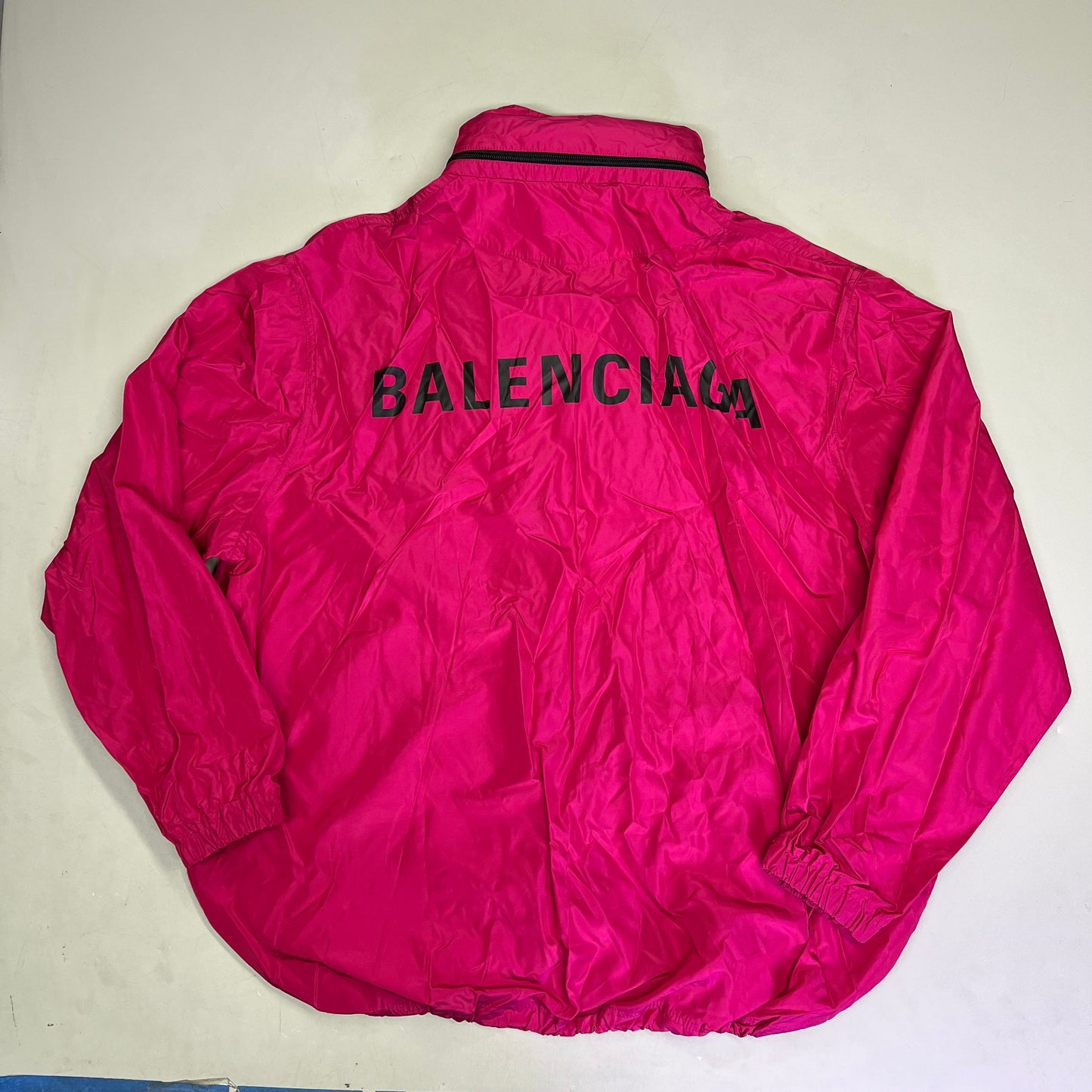 Pink jacket with 'Balenciaga' branding on a light gray background