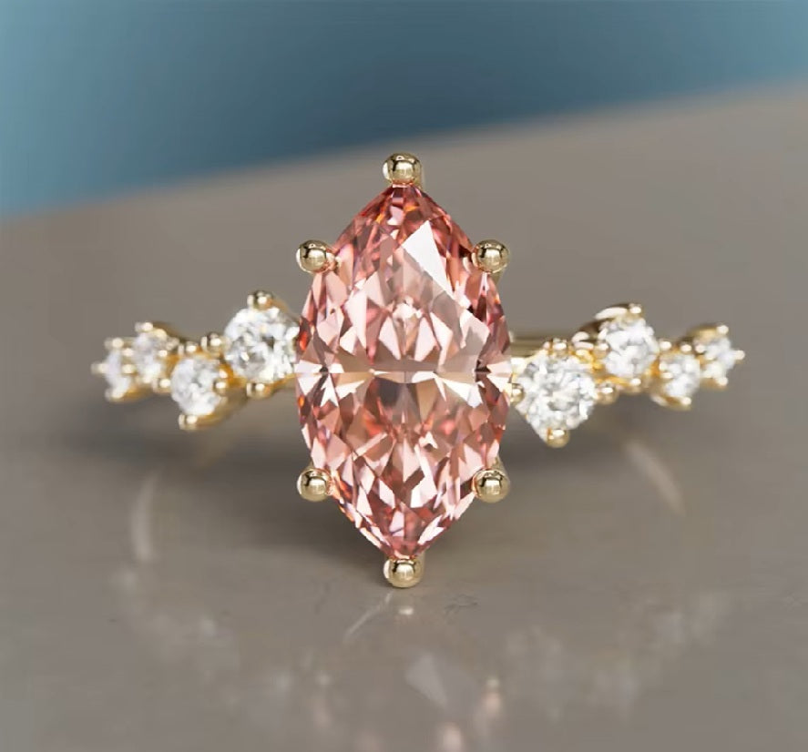 Ring with a pink gemstone and gold accents on a reflective surface. Pink Marquise Lab Grown Diamond Flower Ring in 9K / 14K / 18K Yellow Gold

Delicate, romantic, and endlessly feminine, this pink marquise lab grown diamond ring blooms like a tiny flower on your finger. Crafted in your choice of 9K, 14K, or 18K yellow gold, it’s the perfect symbol of love and tenderness — an unforgettable Valentine’s gift or a meaningful treat just for you.

The soft pink sparkle of the marquise-cut lab diamond