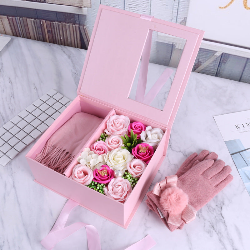 Pink gift box with flowers and pink gloves on a marble surface
