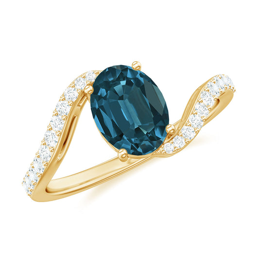 6X8mm Oval Cut London Blue Topaz and Diamond Bypass Engagement Ring