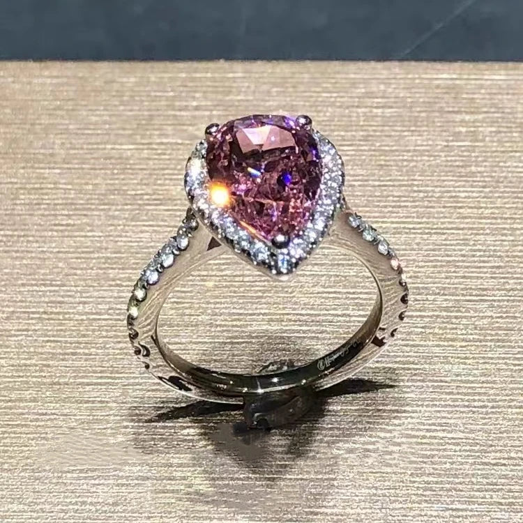 Ring with a pink gemstone and diamond accents on a textured surface Ring with a yellow gemstone and diamond accents on a textured surface 14k Gold 3.5ct Moissanite Jewelry Diamond Ring A bold, architectural silhouette with a “camera-flash” kind of brilliance. Your 3.5ct center stone is held in a precision claw setting designed to maximize light return—finished with 0.35ct of side accents that make the whole ring glow like it has its own spotlight.