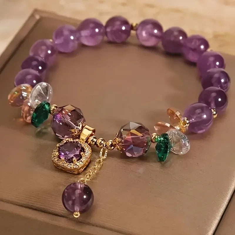 Multicolored beaded bracelet with a gold charm on a wooden surface