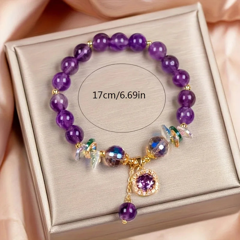 Purple beaded bracelet with charms on a jewelry box