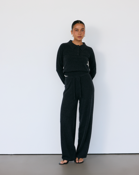 Person wearing a black cashmere outfit against a white background