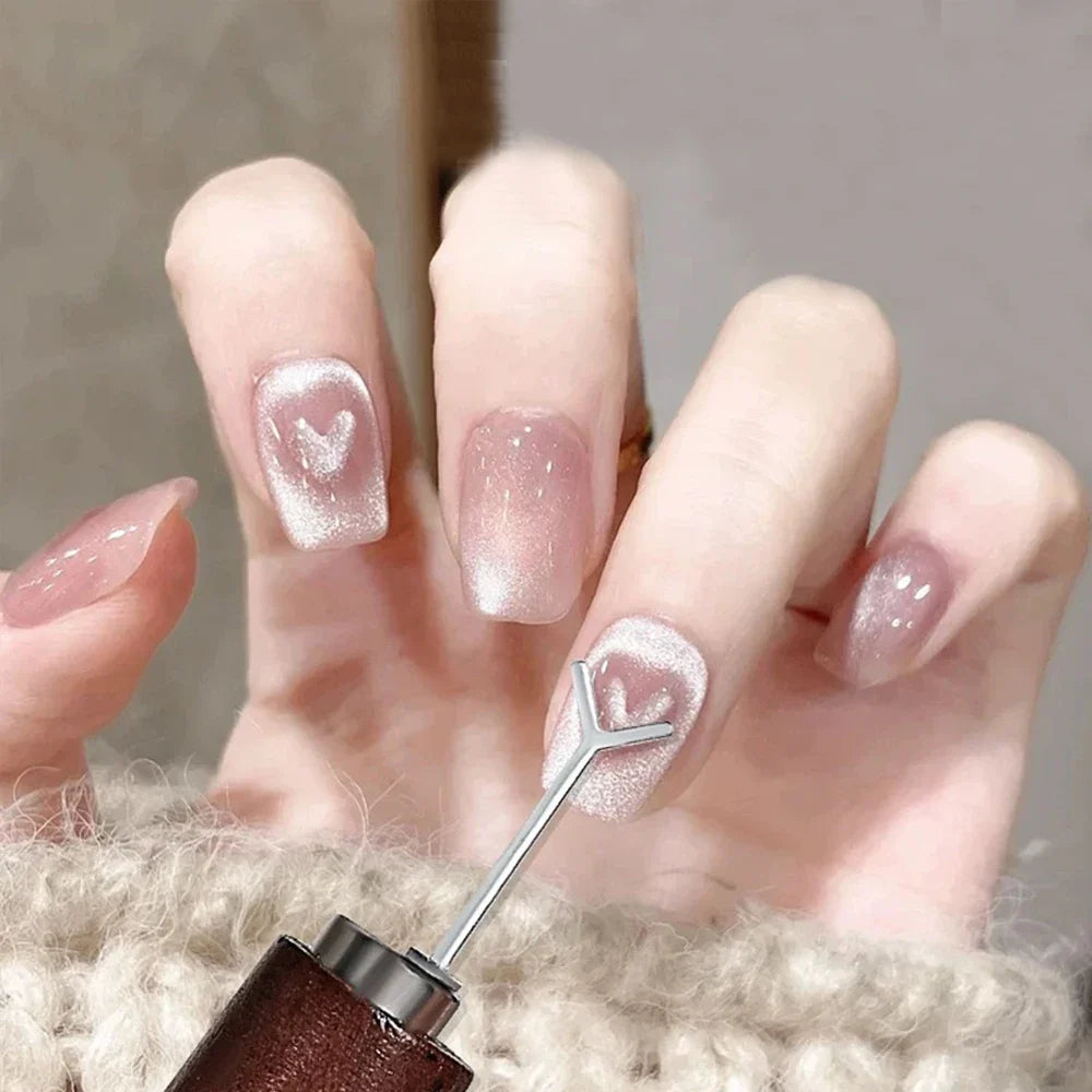 Close-up of a hand applying shimmering, glittery nail polish onto a nail using a brush, set against a clean and neutral background.