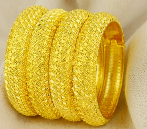 Set of gold bangles on a beige background
