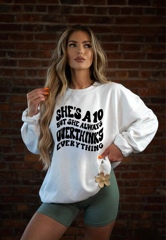 Woman wearing a white sweatshirt with text in front of a brick wall