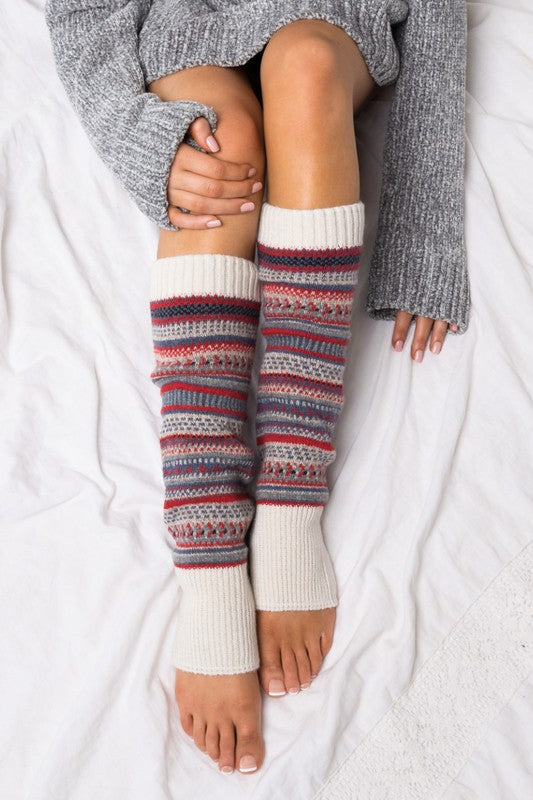 Person wearing patterned leg warmers on a white background