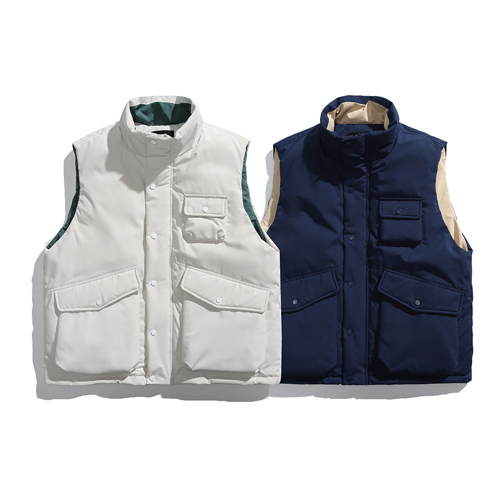 Men's insulated sleeveless puffer workwear vest in beige and navy blue with stand collar, zip front, snap closure, and multiple utility pockets for casual outdoor wear.