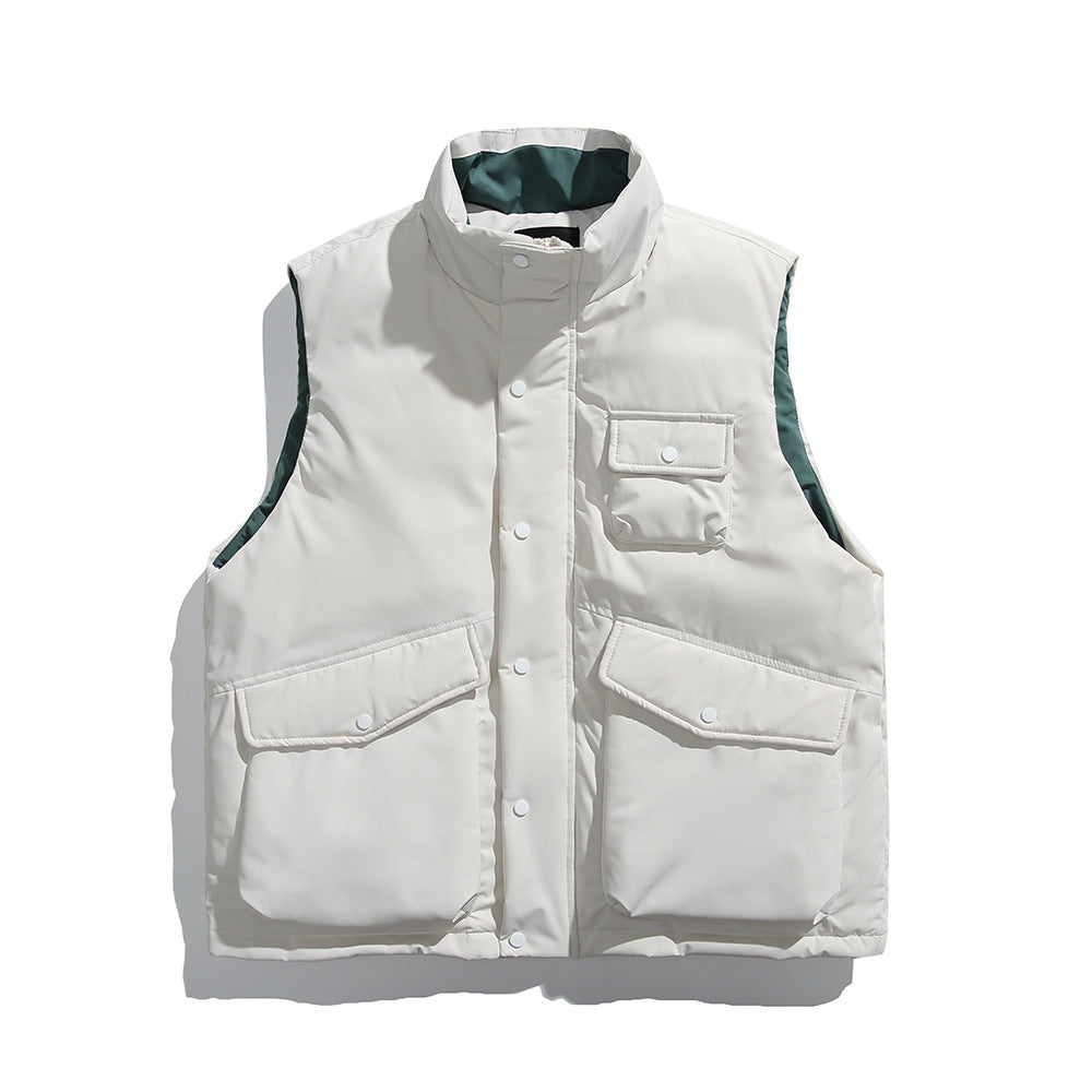 Men's insulated sleeveless puffer workwear vest with stand collar, snap and zip front closure, oversized utility flap pockets, lightweight padded polyester construction, loose fit, beige casual outdoor layering jacket.