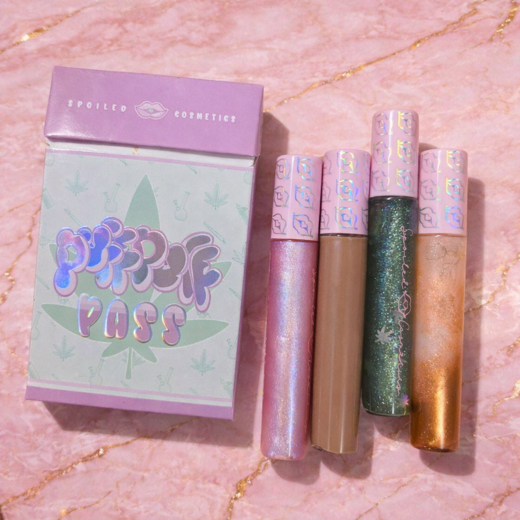 Set of lip glosses with a 'Puff Puff Pass' packaging on a pink marble background