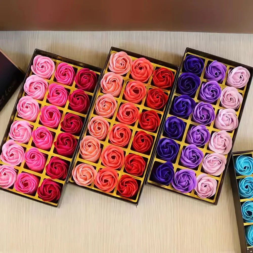 Three boxes of colorful soap roses on a wooden surface