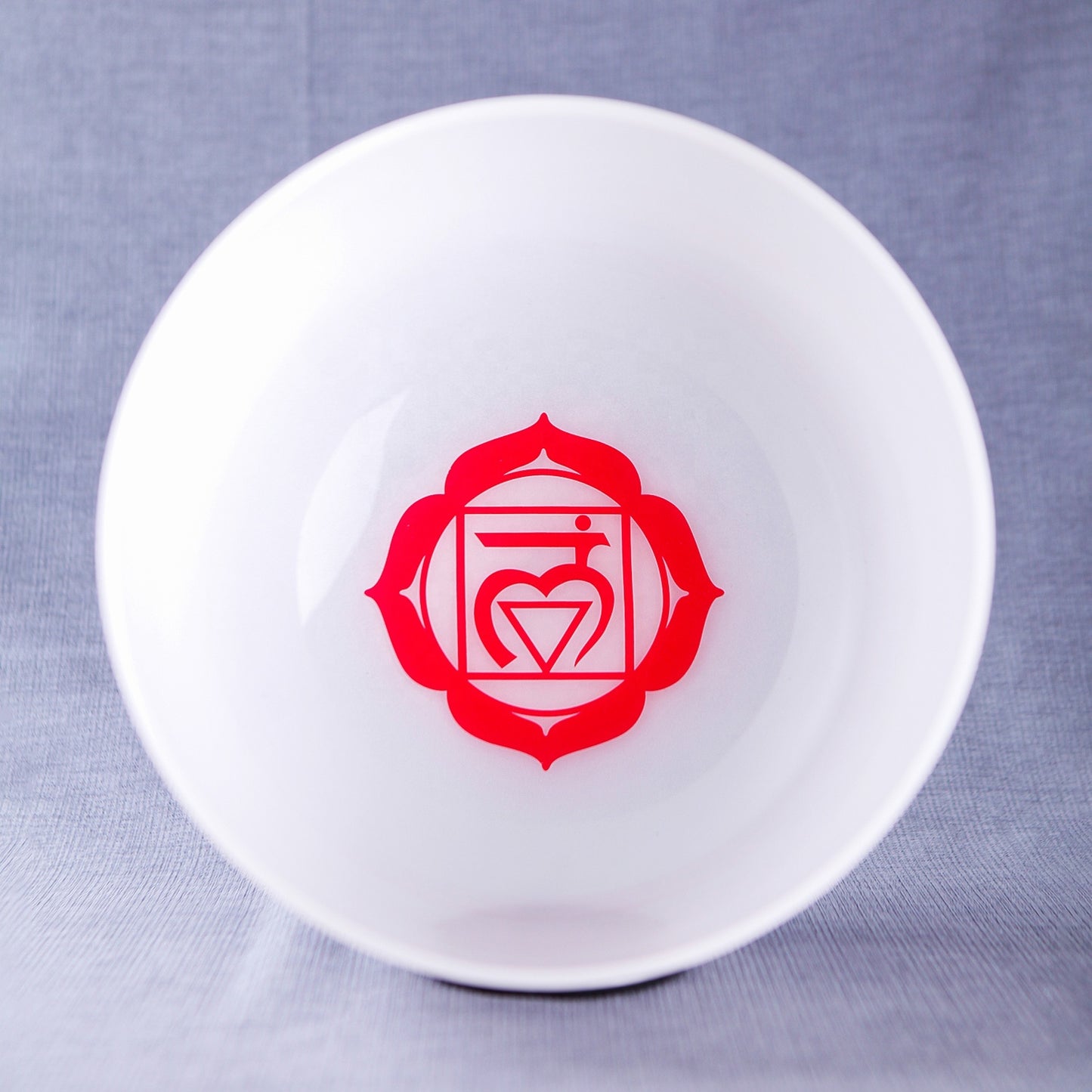 White dish with a red emblem on a gray background Three white stress balls with different symbols and a hammer on a gray background Set of small white bowls with colorful symbols on a woven mat - Seven Chakra Crystal Buddha Sound Bowl multicolor rainbow chakra Crystal Buddha sound bath