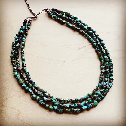Triple Strand Turquoise & Wood Collar Necklace TRIPLE STRAND • TURQUOISE + WOOD • STATEMENT COLLAR
Triple Strand Turquoise &amp; Wood Collar Necklace

Make a bold statement with a triple strand collar necklace where rich turquoise stones meet warm wood accents for an effortlessly chic, collected look. Every piece is made with natural materials, so no two necklaces ever match—your collar will have its own mix of gemstone sizes and signature patterning. Wear it solo as your centerpiece or layer it with longer