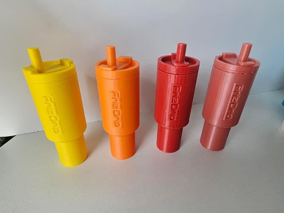 Yellow, orange, red, and mauve tumbler-style silicone lip balm holder keychains standing upright on a white surface, designed to hold standard lip balm tubes and attach to keys, purses, backpacks, and handbags.