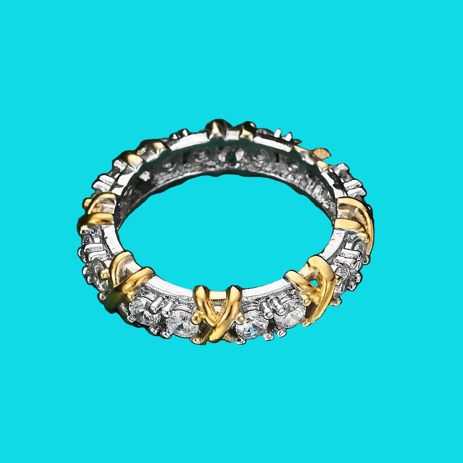 Two-tone ring with gold and silver accents on a green textured surface