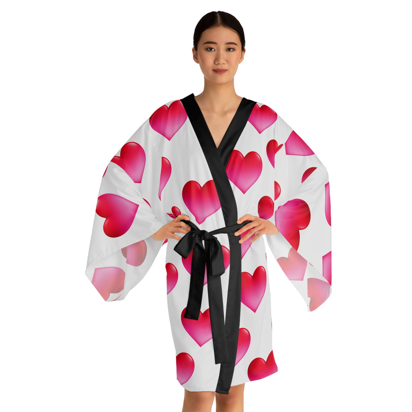Woman wearing a white robe with pink hearts and a black belt on a white background