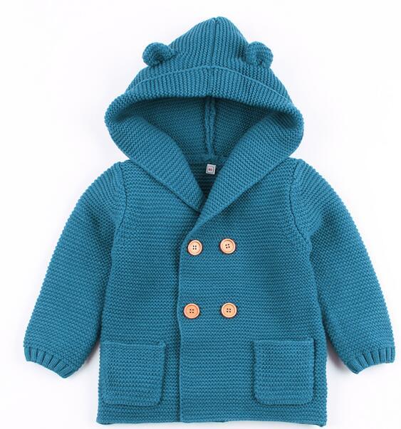 Blue knitted children's coat with hood on a white background