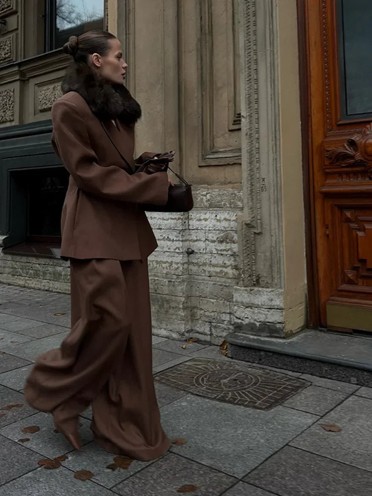 Woman in a brown outfit standing on a street with a building in the background oversized blazer business suit for women chic business suit