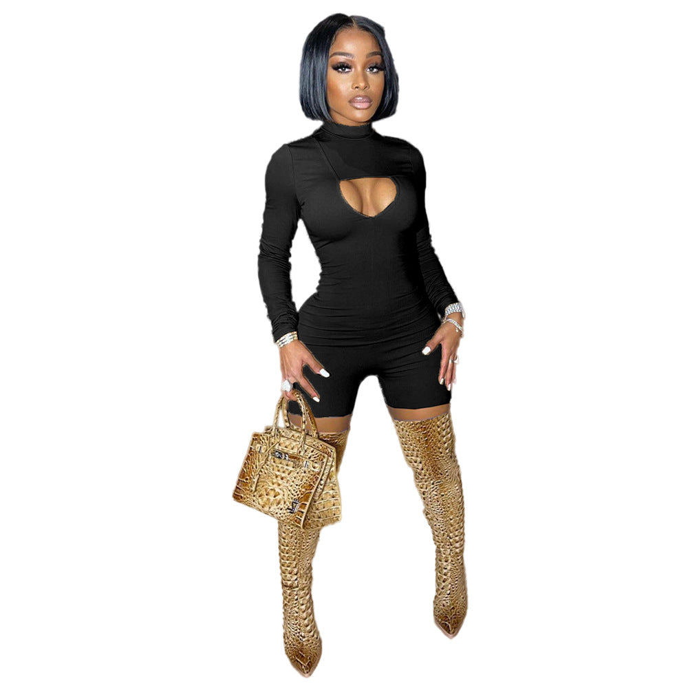 Woman in black outfit with cut-out design, holding a leopard print handbag on a white background