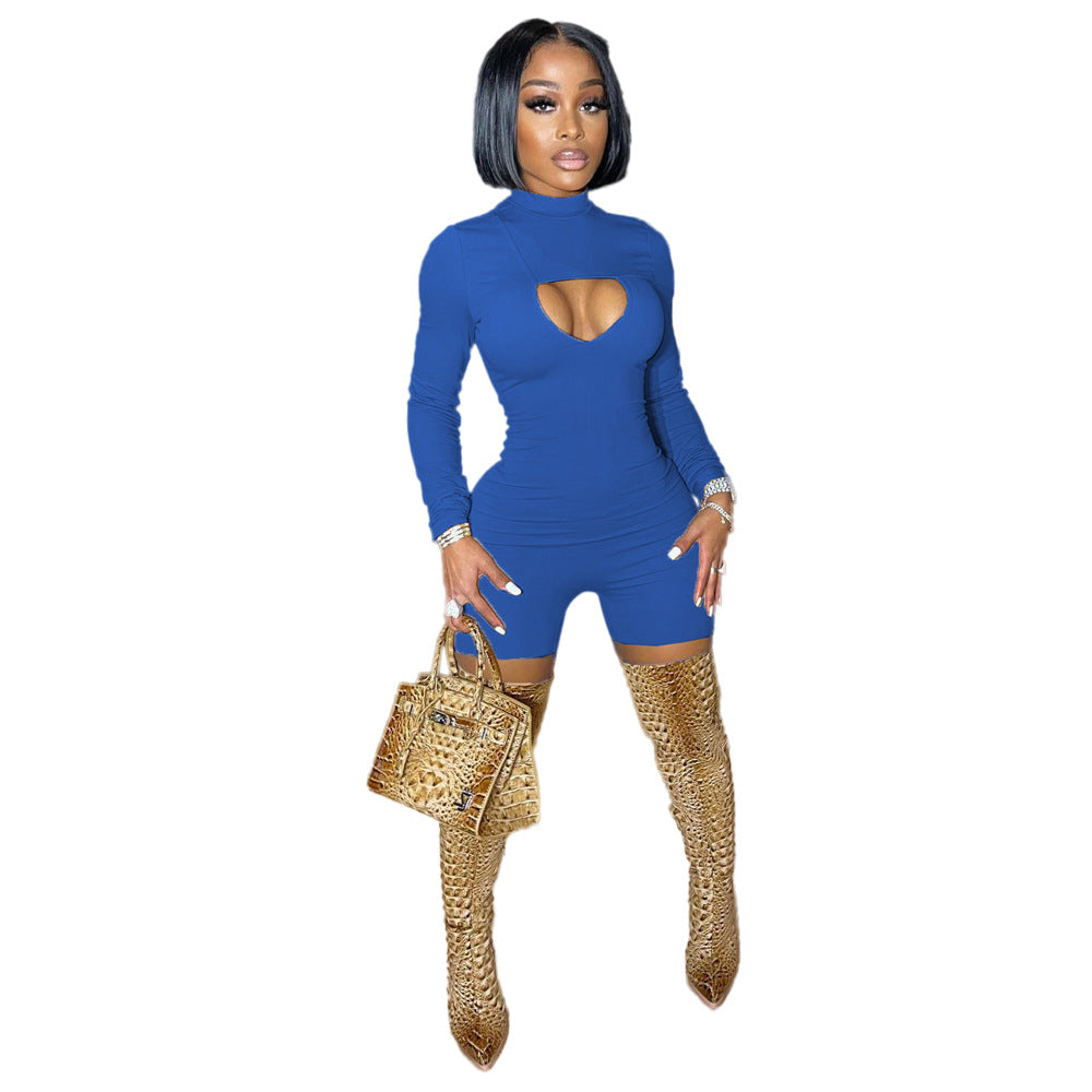 Woman wearing a blue outfit with cut-out design and gold high-heeled shoes on a white background