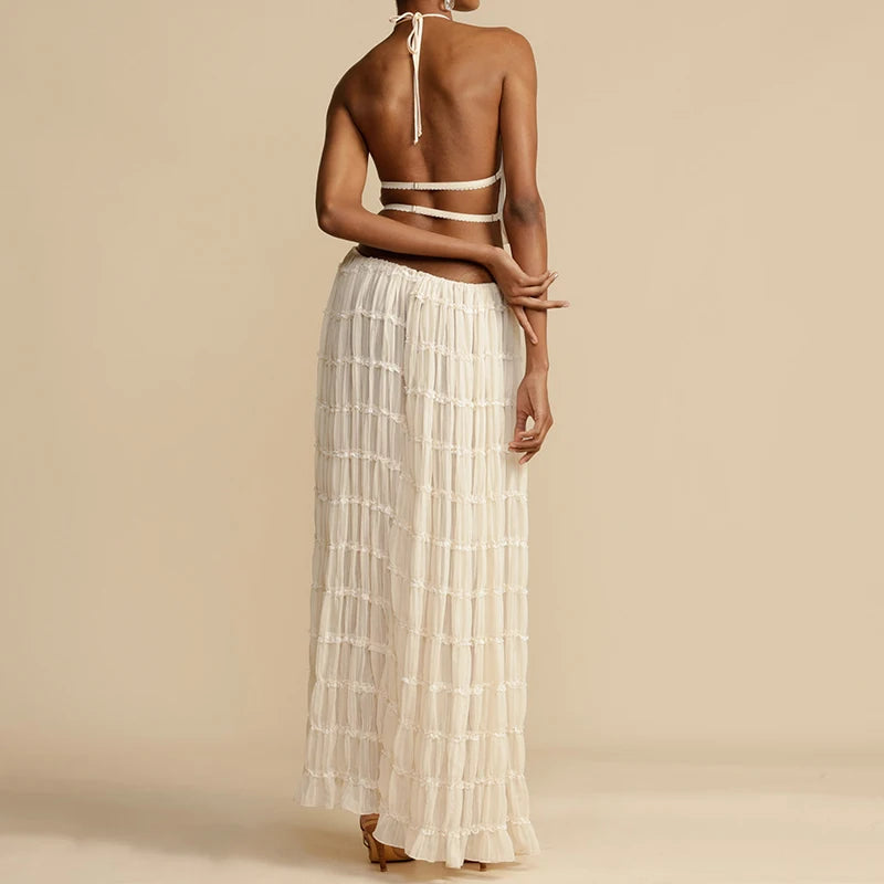 Woman wearing a white bikini and long skirt on a beige background