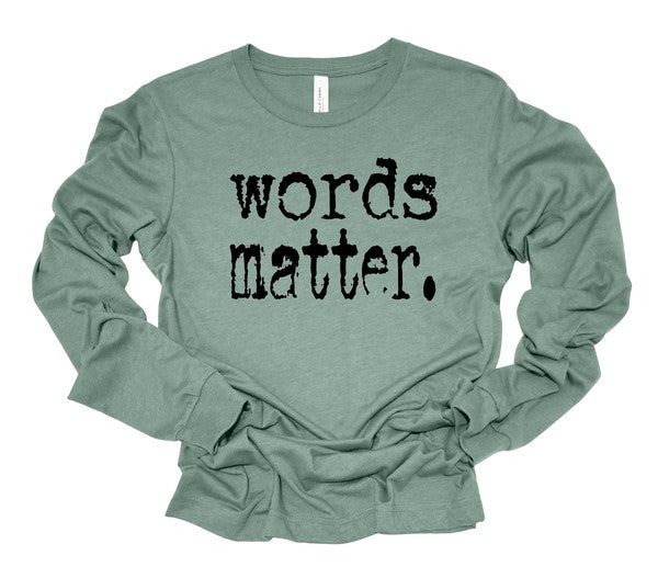 Sage green long sleeve graphic tee featuring distressed black "words matter." text across the front, displayed flat on a white background.