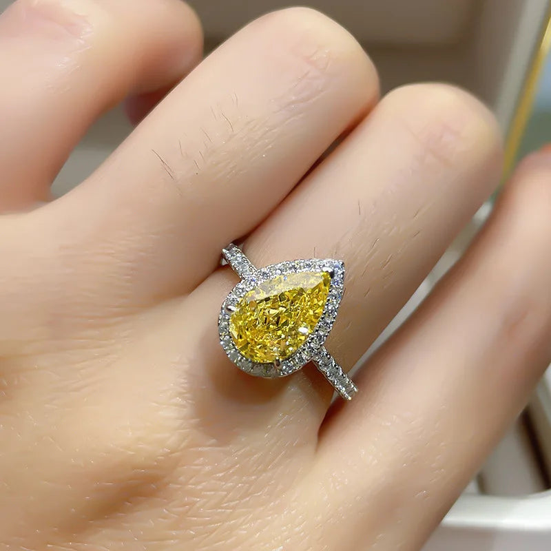 Yellow diamond ring with silver setting on a hand 14k Gold 3.5ct Moissanite Jewelry Diamond Ring A bold, architectural silhouette with a “camera-flash” kind of brilliance.  YELLOW DIAMONDS