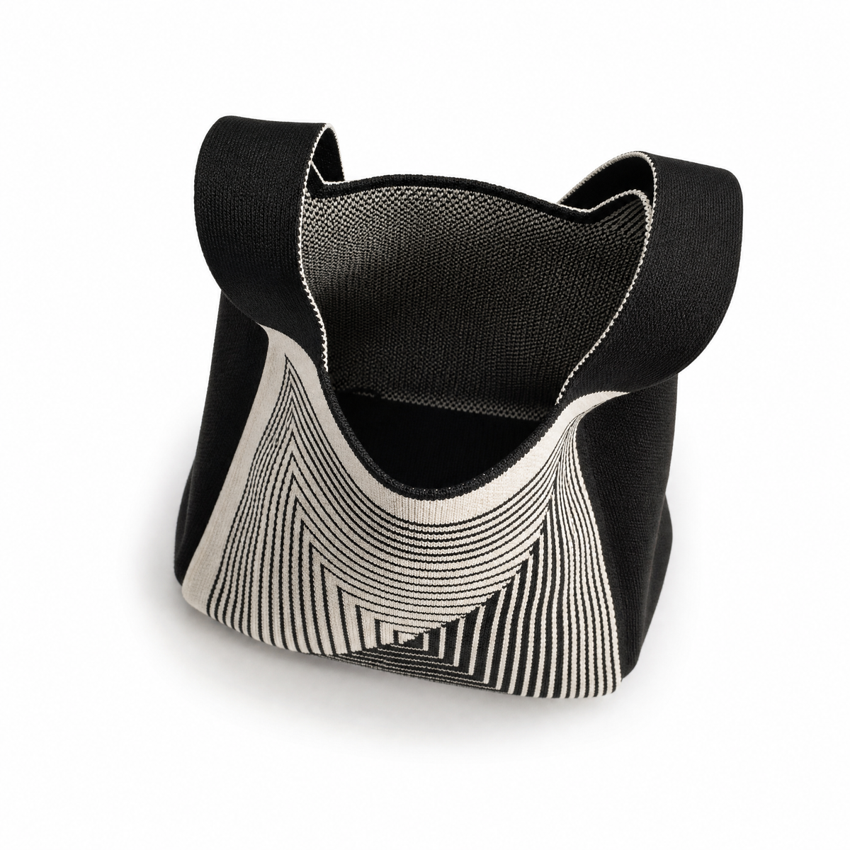 A black and white geometric patterned tote bag with integrated shoulder straps, shown on a clean white background.