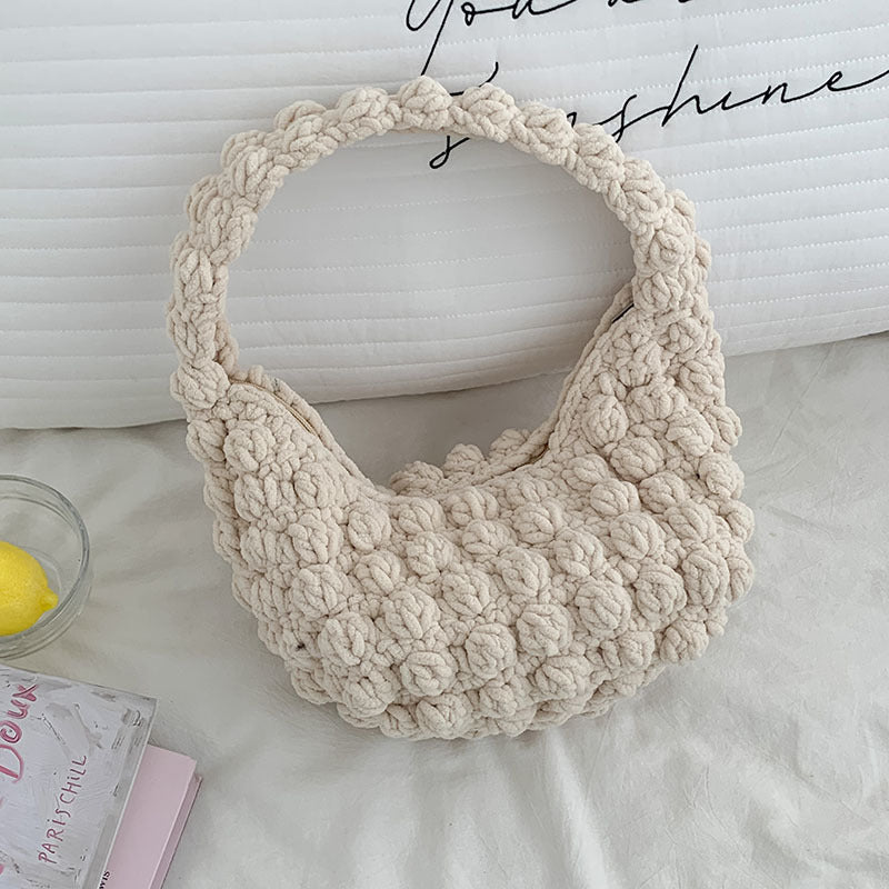 Beige crochet bag on a white surface with text in the background