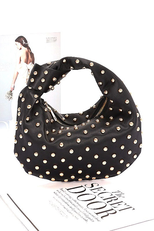 Elevate your evening look with this stunning studded clutch—the perfect blend of sophistication and sass. Featuring a chic knotted handle and soft satin construction, this compact purse slides effortlessly into your night out. The mixed metal studs add just the right amount of edge, while the polyurethane backing ensures durability. At 10" wide and 7" tall, it's sized just right for essentials. Lead and nickel compliant for worry-free style. Your new go-to accessory for turning heads.