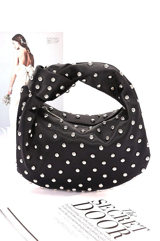 Elevate your evening look with this stunning studded clutch—the perfect blend of sophistication and sass. Featuring a chic knotted handle and soft satin construction, this compact purse slides effortlessly into your night out. The mixed metal studs add just the right amount of edge, while the polyurethane backing ensures durability. At 10" wide and 7" tall, it's sized just right for essentials. Lead and nickel compliant for worry-free style. Your new go-to accessory for turning heads. Black Bag with studs