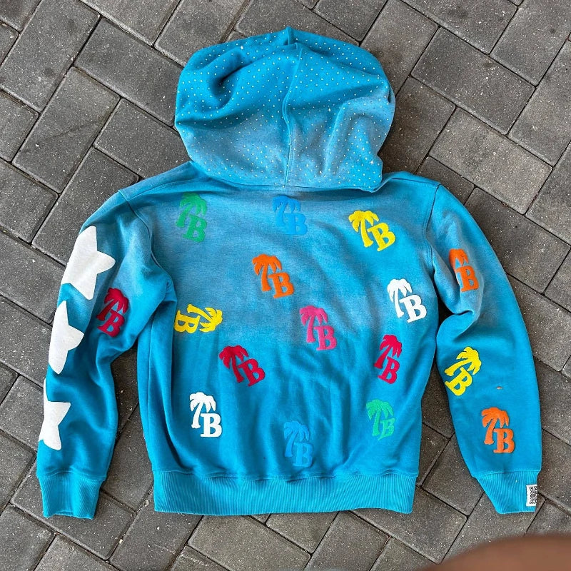 Blue hoodie with colorful logos on a gray pavement