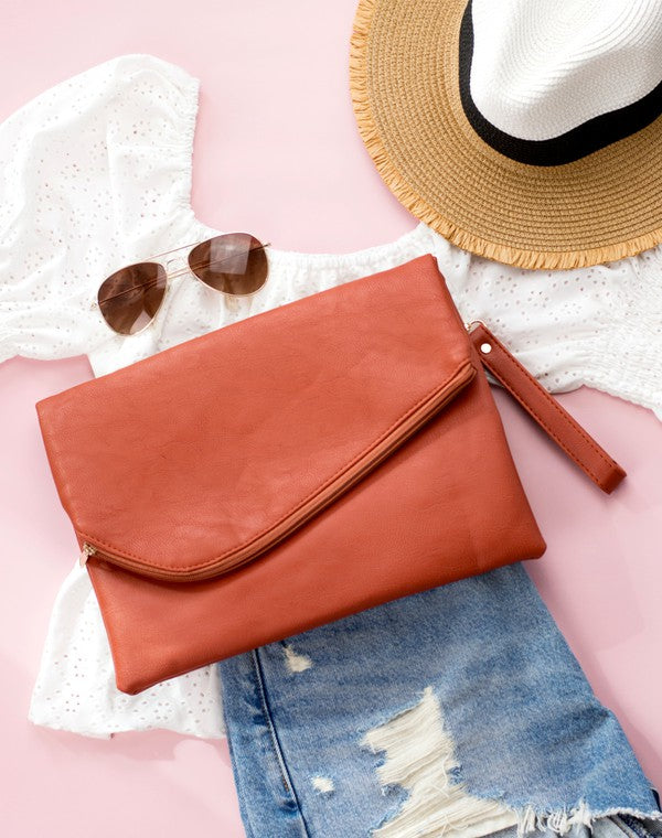 burnt sienna foldover clutch bag Simple, sleek, and ready for whatever comes next. This oversized foldover envelope clutch is crafted from soft vegan PU with a fully lined, easy-wipe polyester interior. A top zipper envelope closure + snap keeps everything secure, and the removable wristlet makes carrying effortless.