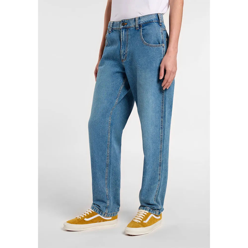 Person wearing blue jeans and yellow sneakers on a white background