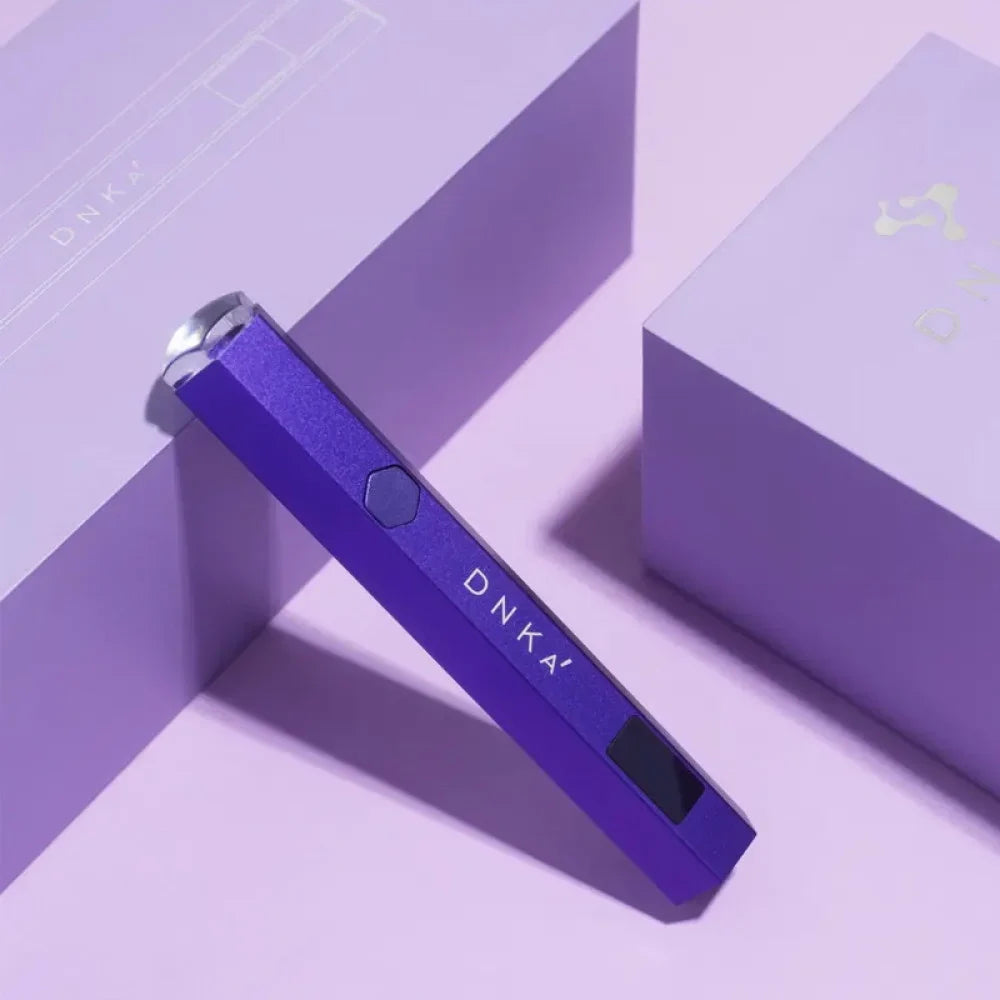 Purple DNKa Lumos Light UV/LED flashlight standing upright on a textured, geometric purple background.