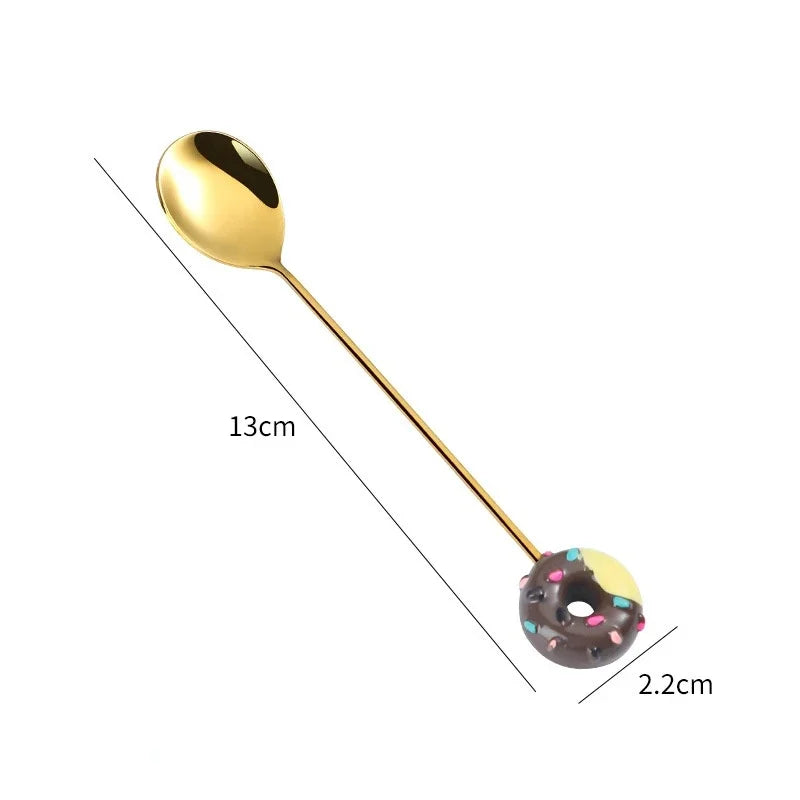 Gold spoon with a donut-shaped handle on a white background, showing measurements.
