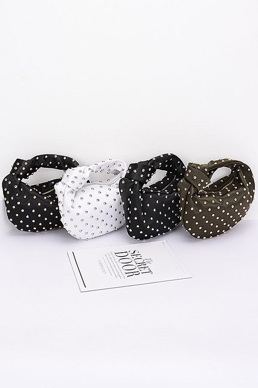 Elevate your evening look with this stunning studded clutch—the perfect blend of sophistication and sass. Featuring a chic knotted handle and soft satin construction, this compact purse slides effortlessly into your night out. The mixed metal studs add just the right amount of edge, while the polyurethane backing ensures durability. At 10" wide and 7" tall, it's sized just right for essentials. Lead and nickel compliant for worry-free style. Your new go-to accessory for turning heads.