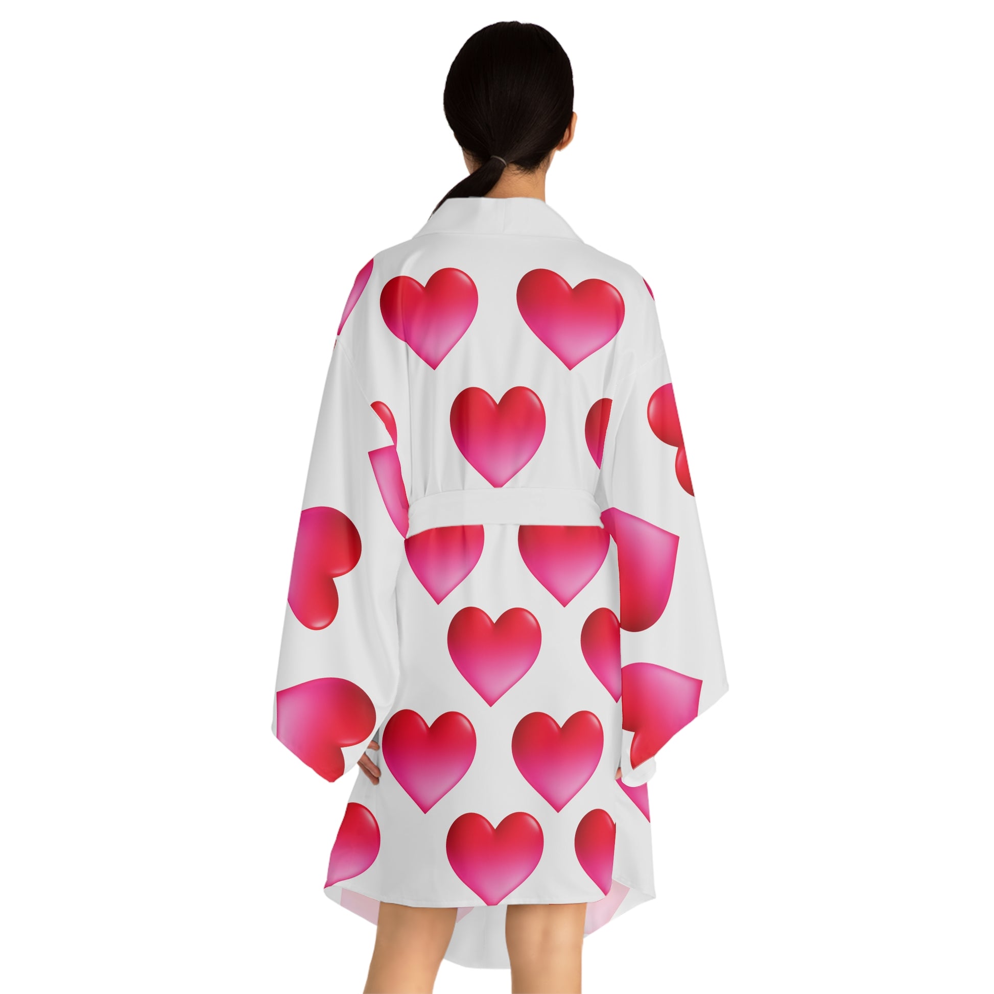 Woman wearing a white kimono-style garment with pink heart patterns on a white background