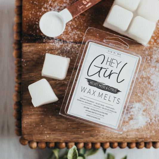 Rustic flat lay of HEY Girl Velvet Moss & Citrus soy wax melts with white wax cubes, wooden scoop, and cozy home décor on a wooden tray, featuring handmade USA artisan wax melts.