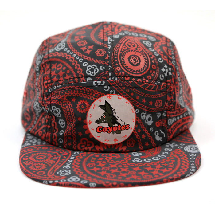 A red and black paisley bandana-patterned flat-brim cap with a circular front patch featuring a coyote graphic and the word 'Coyotes'.