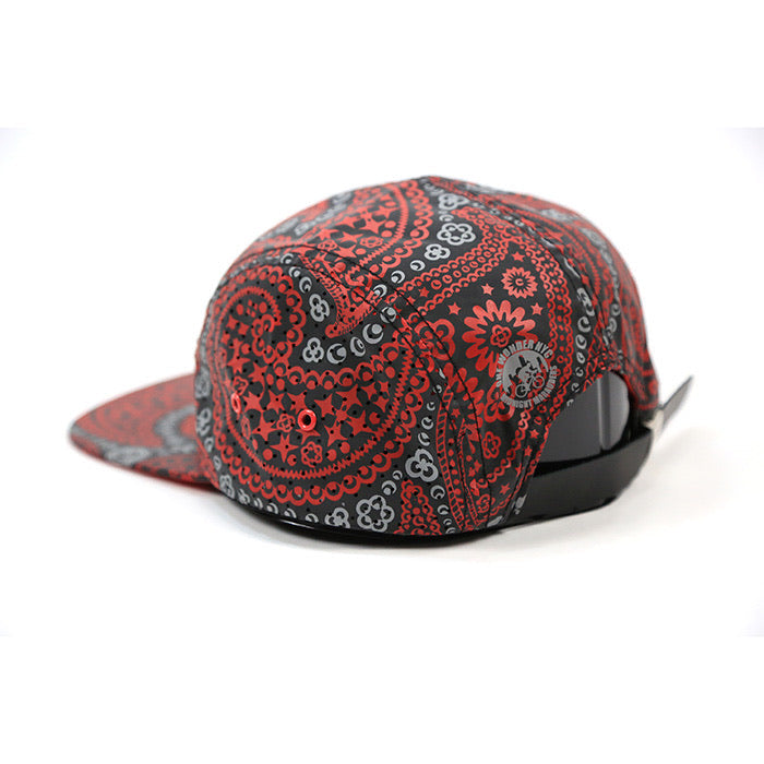 A red and black paisley bandana-patterned snapback cap shown from a three-quarters angle on a white background.