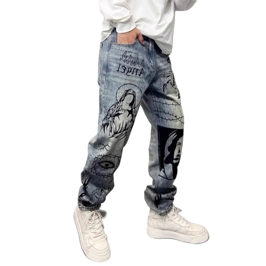 Person wearing jeans with graphic designs and white sneakers on a white background.
