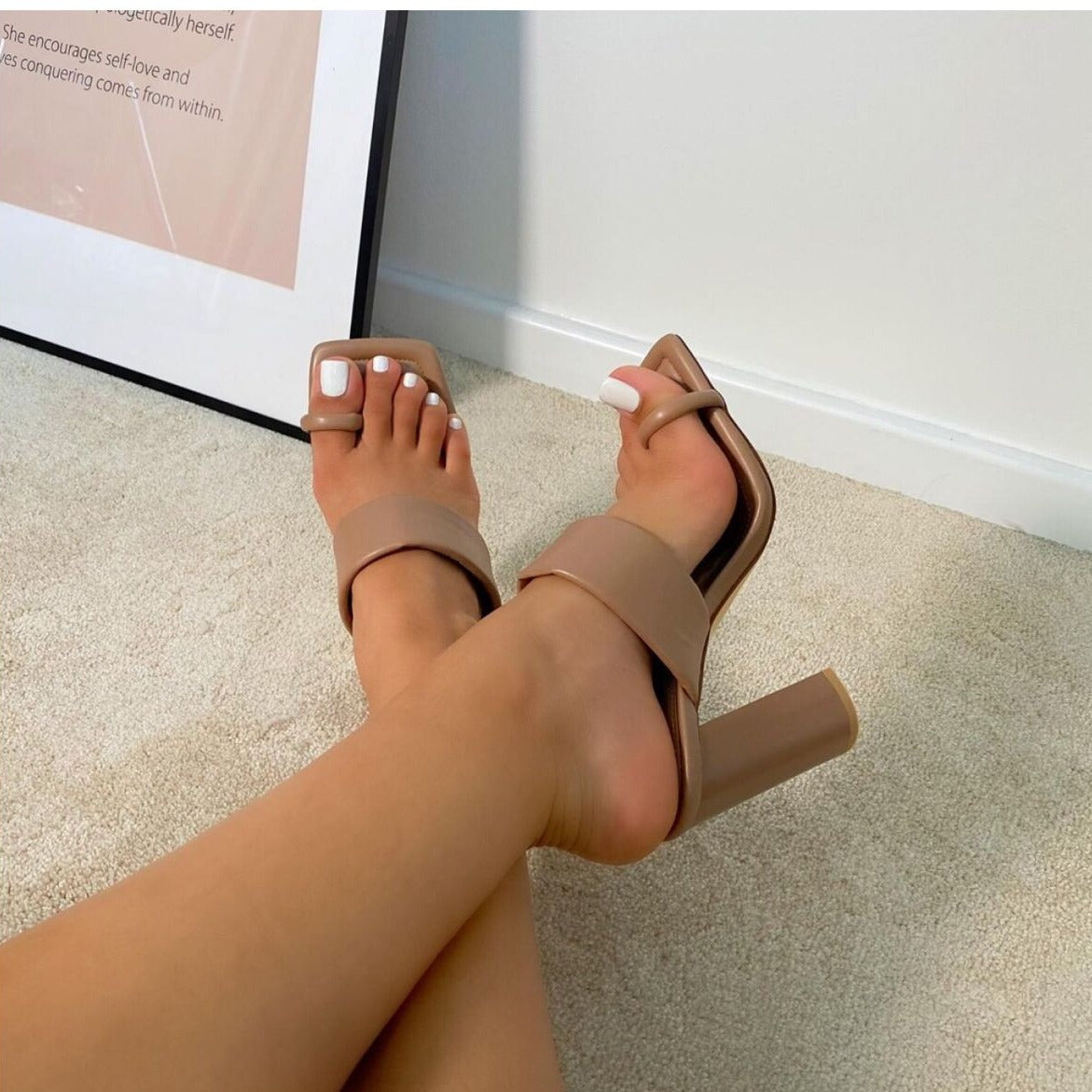 light brown Beige high-heeled sandals worn on a carpeted floor.