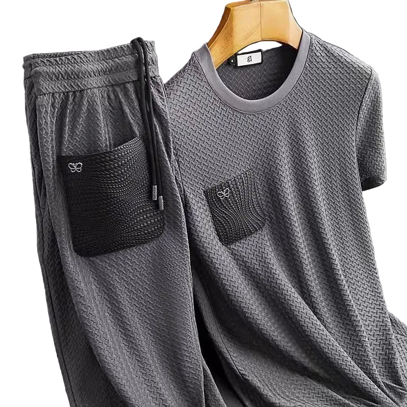 Gray t-shirt and pants set with pockets on a hanger against a gray background