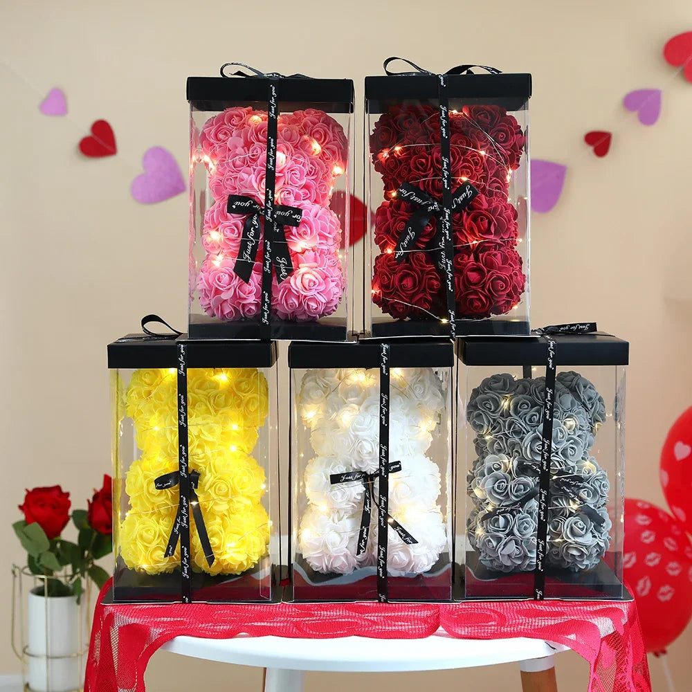 Colorful rose-shaped bears with LED lights in clear packaging on a table.