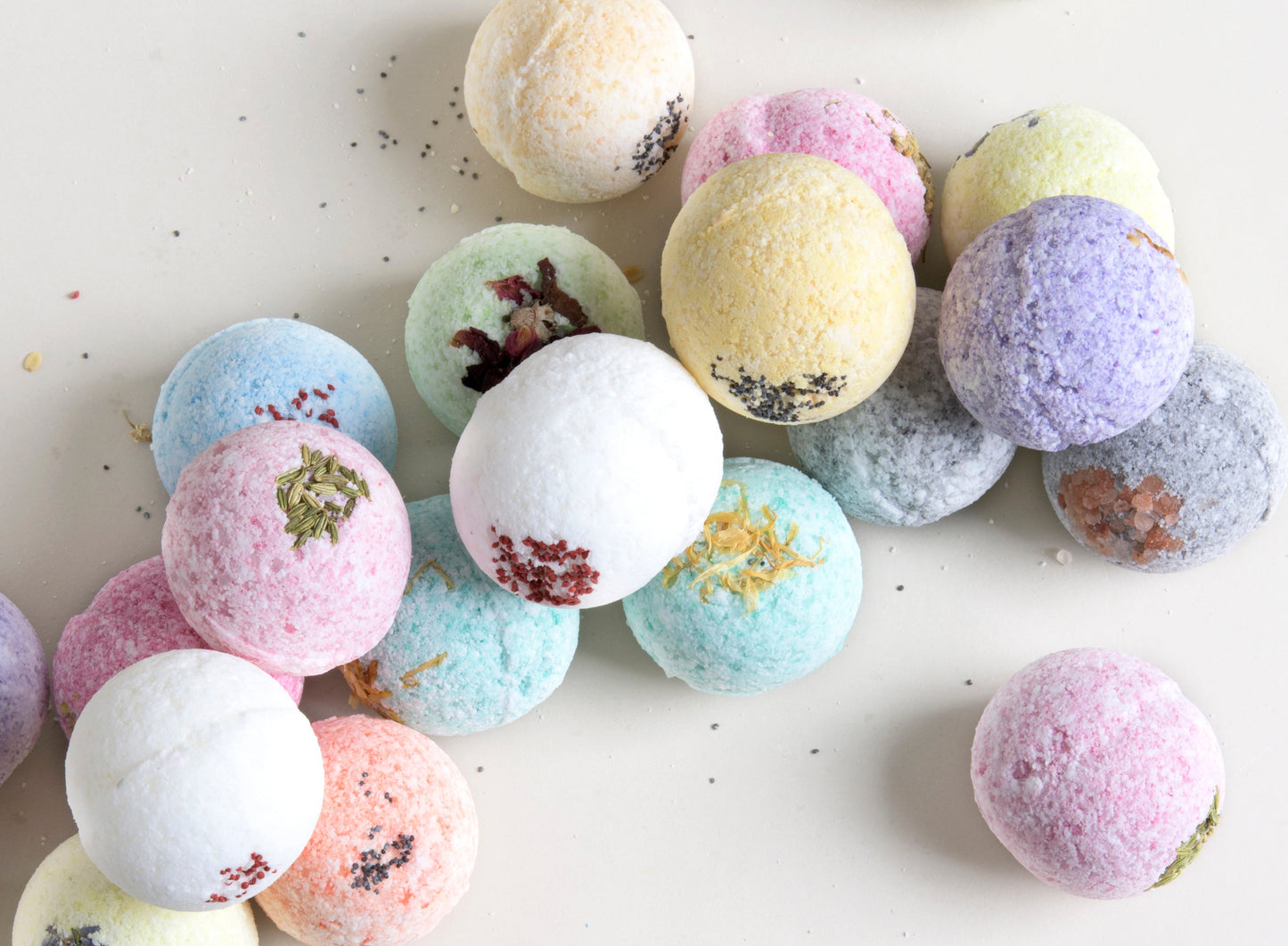 Pastel-colored bath bombs with decorative elements on a light background