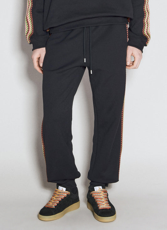 A pair of black Lanvin cotton fleece track pants featuring a drawstring waistband, colorful embroidered curb-style straps along the sides, and a rear logo embroidery, displayed on a white background.