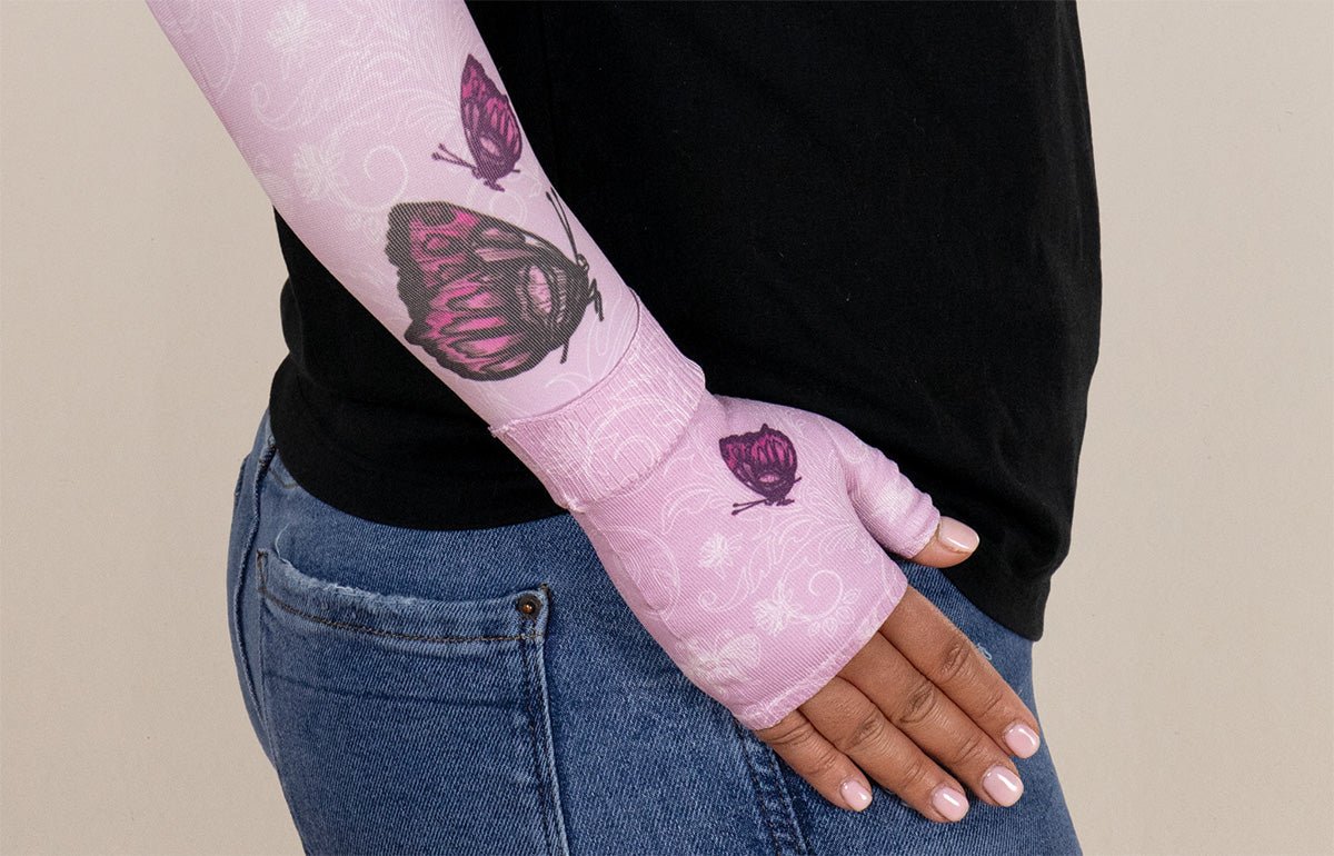 Person wearing a pink cast with butterfly designs on a beige background